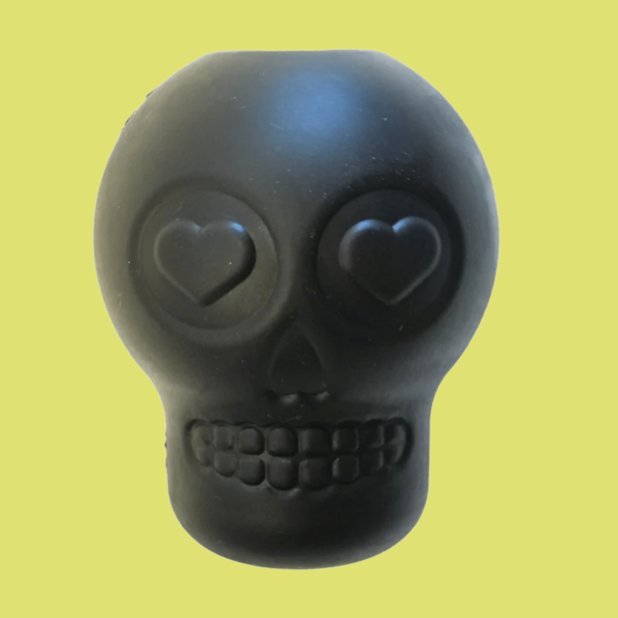 Farmto-pettreats Dog Treat Dispenser Black skull-shaped with heart eyes on a yellow background