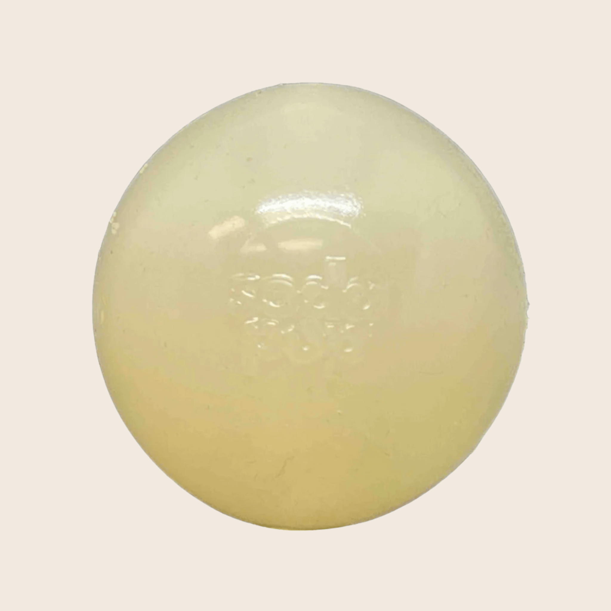 A Farmto-pettreats Dog Fetch Ball Glow-in the Dark Squeak ball is Round, white colored on a light beige background.