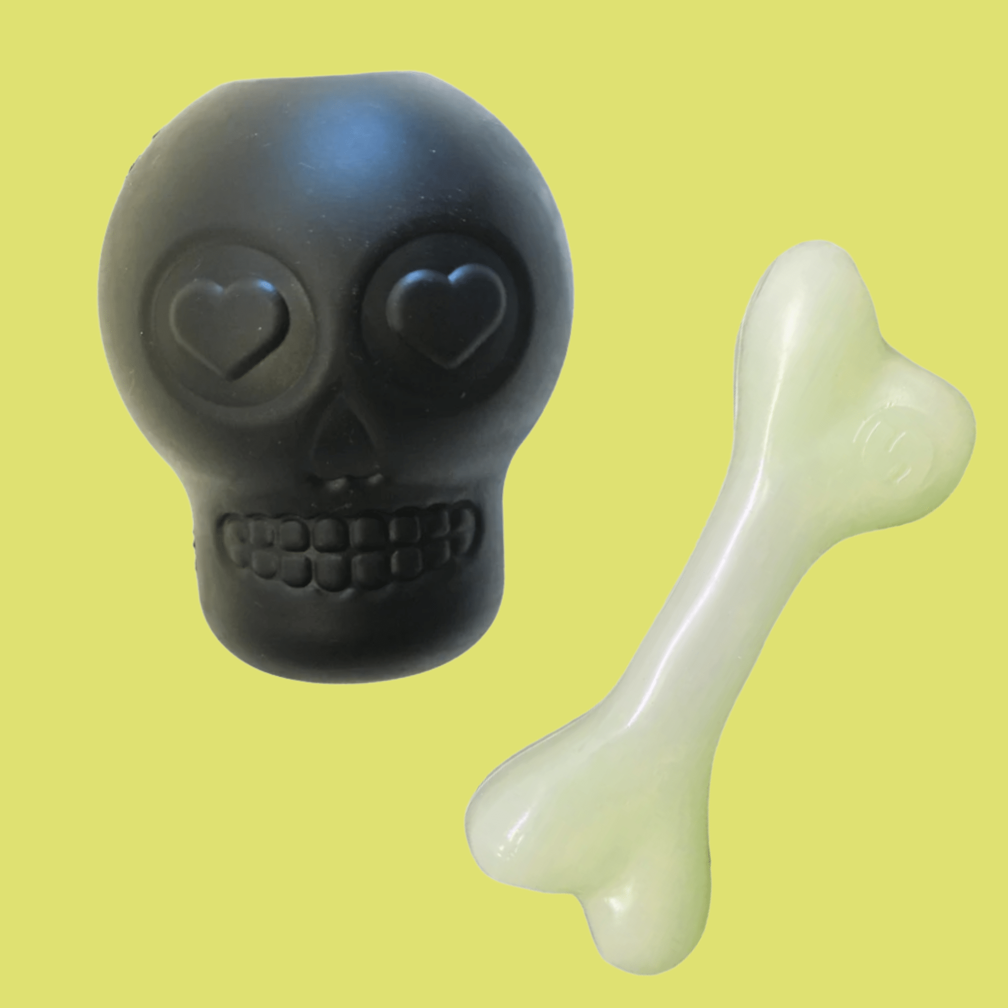 Farmto-pettreats Dog Treat Dispensers Black skull-shaped and white bone-shaped toy on a yellow background