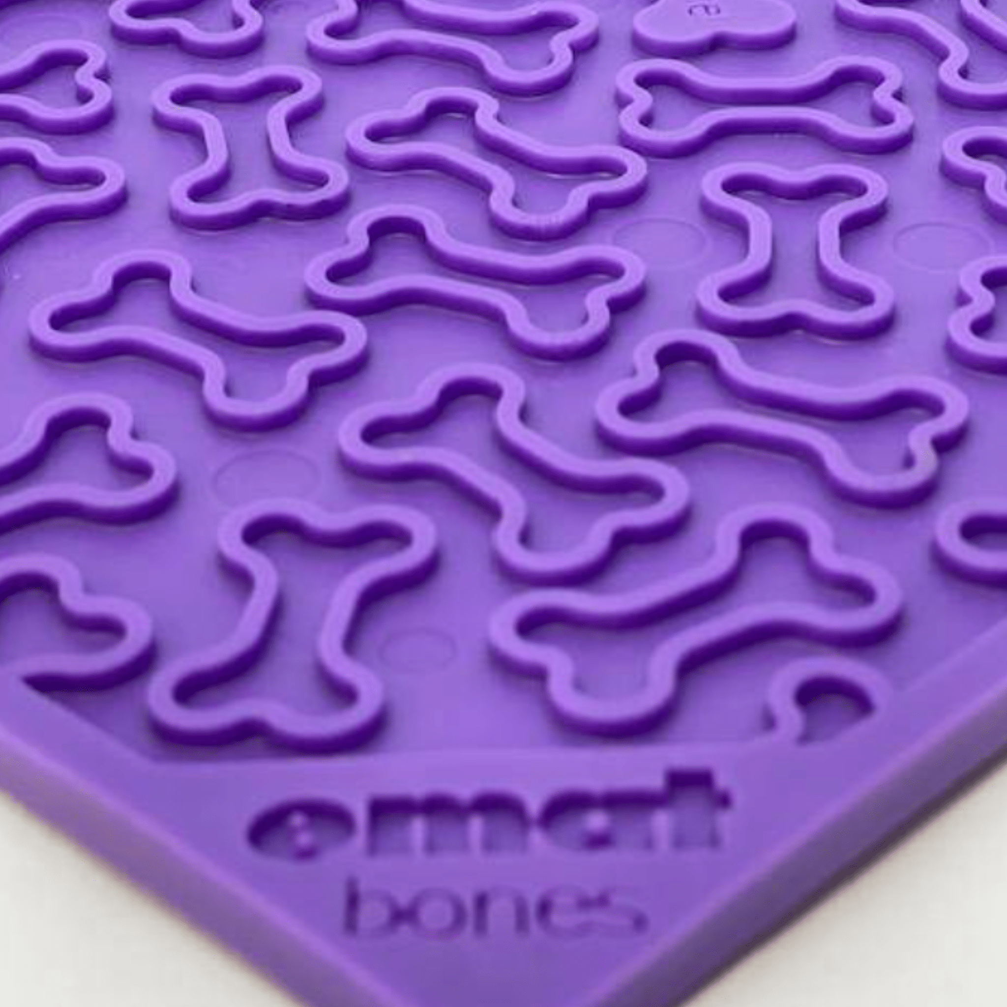 Farmto-pettreats Purple silicone lick mat with bone shapes on a white background.