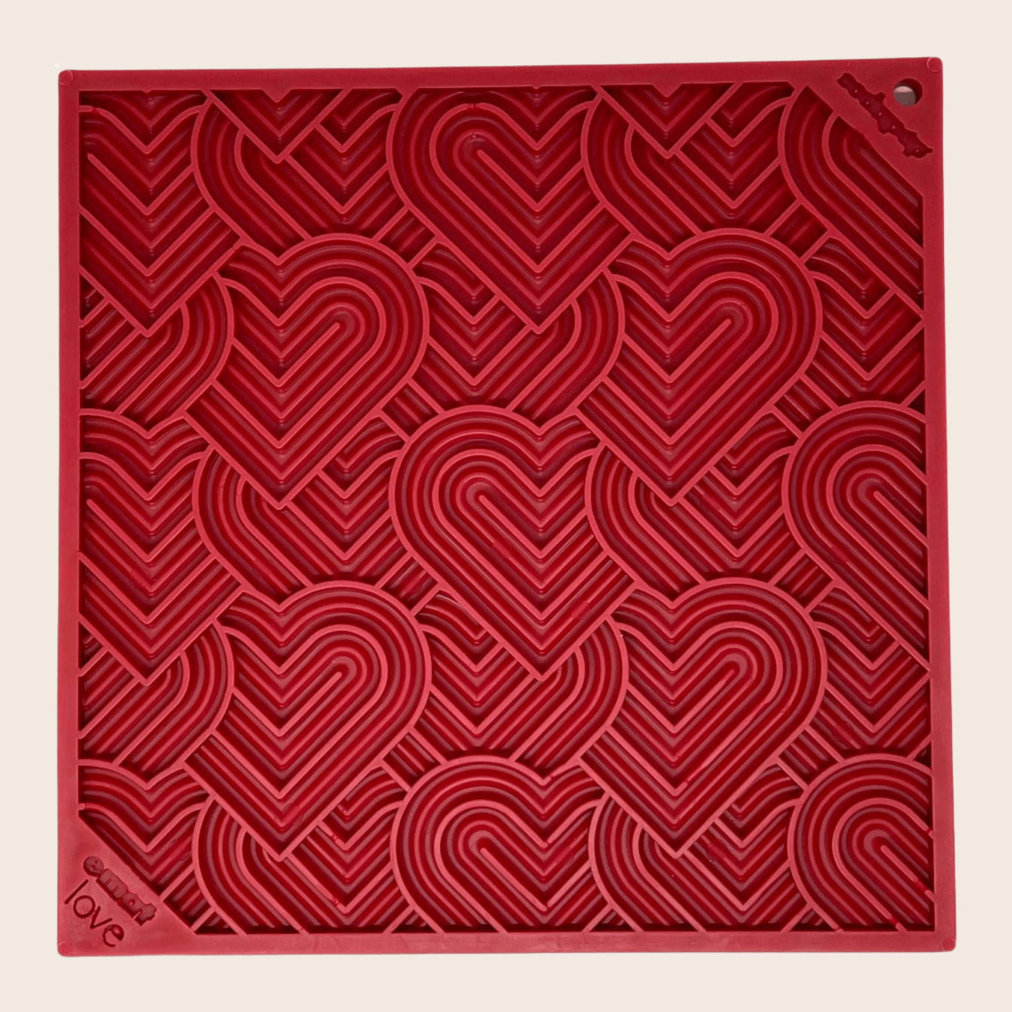 Farmto-pettreats Red Heart lick mat  textured square with heart patterns on a beige background.