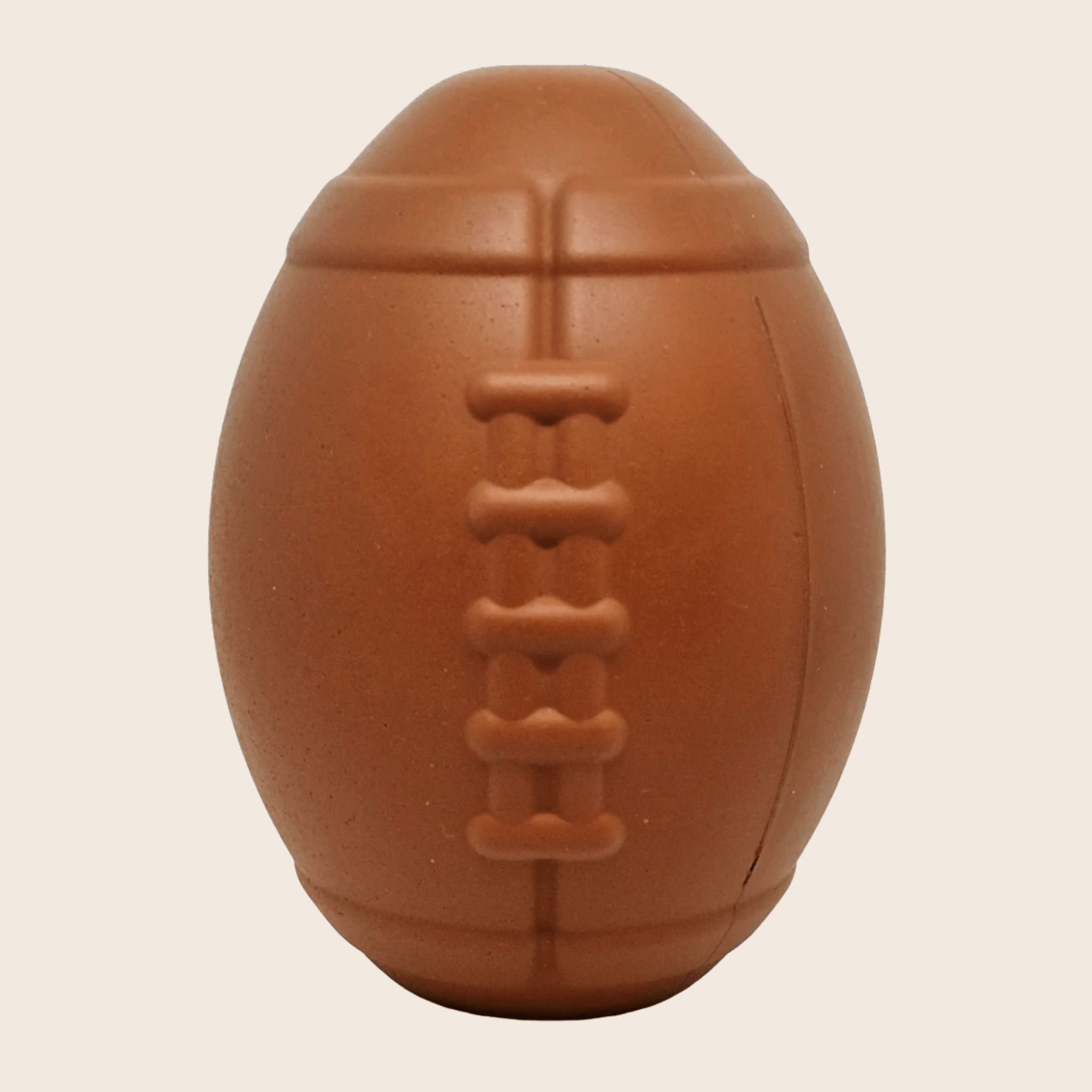 Farmto-pettreats Dog Treat Dispenser Brown football on a beige background.