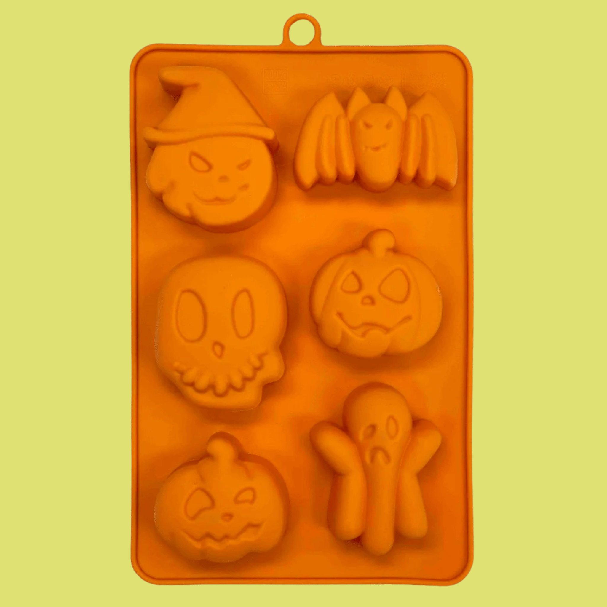 Farmto-pettreats Halloween Pet Treat Mold  made of Orange silicone with Halloween-themed shapes on a yellow background back of mold.