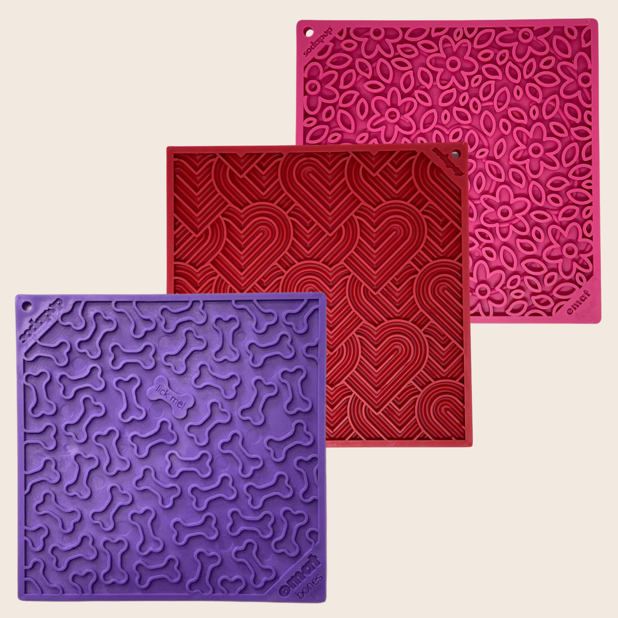 Farmto-pettreats Dog Lick Mats Three silicone mats in purple, red, and pink with textured patterns on a beige background.