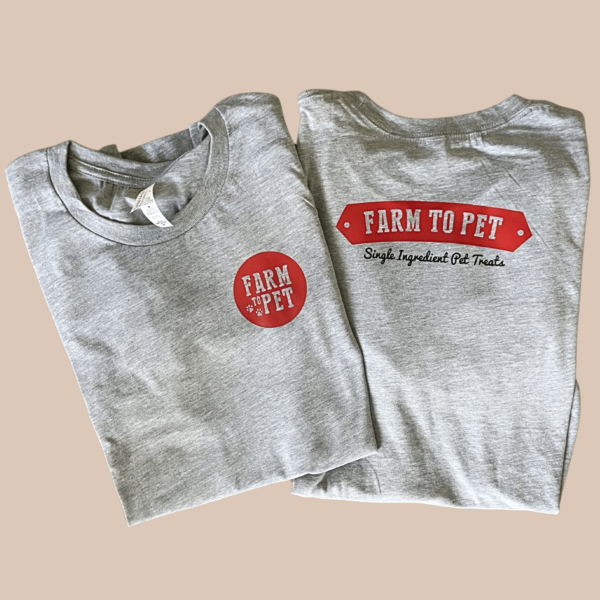 Two folded gray t-shirts showing the front and back with Farmto-pettreats branding on a beige background.