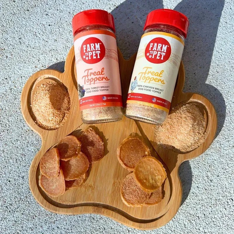 A wooden paw board and two jars with Farmto-pettreats Chicken Chips and  sprinkled with Chicken & Turkey Combo Topper Pack 