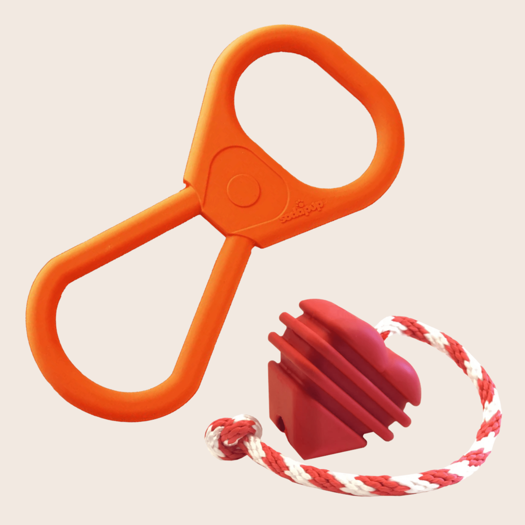 Farmto-pettreats Tug Toys Pop Top Tug is Orange plastic Tug and Heart On a String Tug with a red and white rope attachment on a beige background.